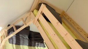 Een houten bedframe met een matras en kussens.