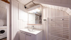 A bathroom with a white sink, mirror, and towel rack. - Apartment 'Nature Summer and Ski Winter' with Wi-Fi (Moutiers)
