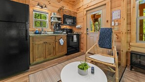 Interno di una baita in legno con cucina, sala da pranzo e camino.