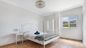 A bedroom with a bed, nightstand, and a window with a view. - 2-bed House Sleeps 4 With Free Parking (Puerto de la Cruz)