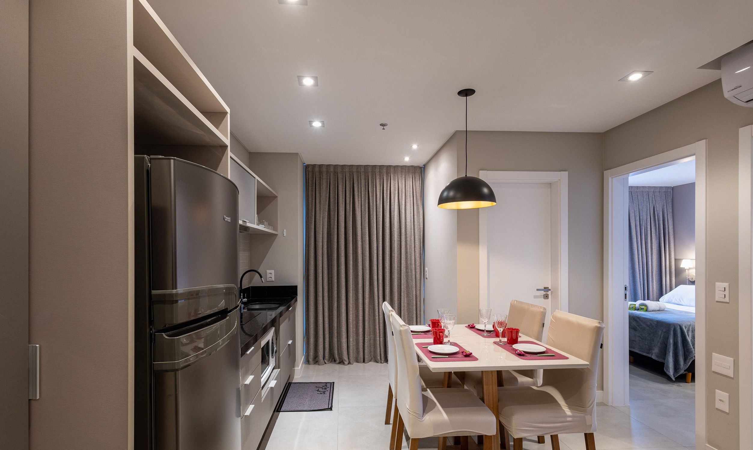 A modern kitchen with a built-in oven and a dining area with a table set for two.