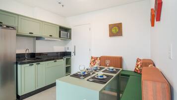 A compact kitchen with a dining area, a microwave, and a refrigerator.