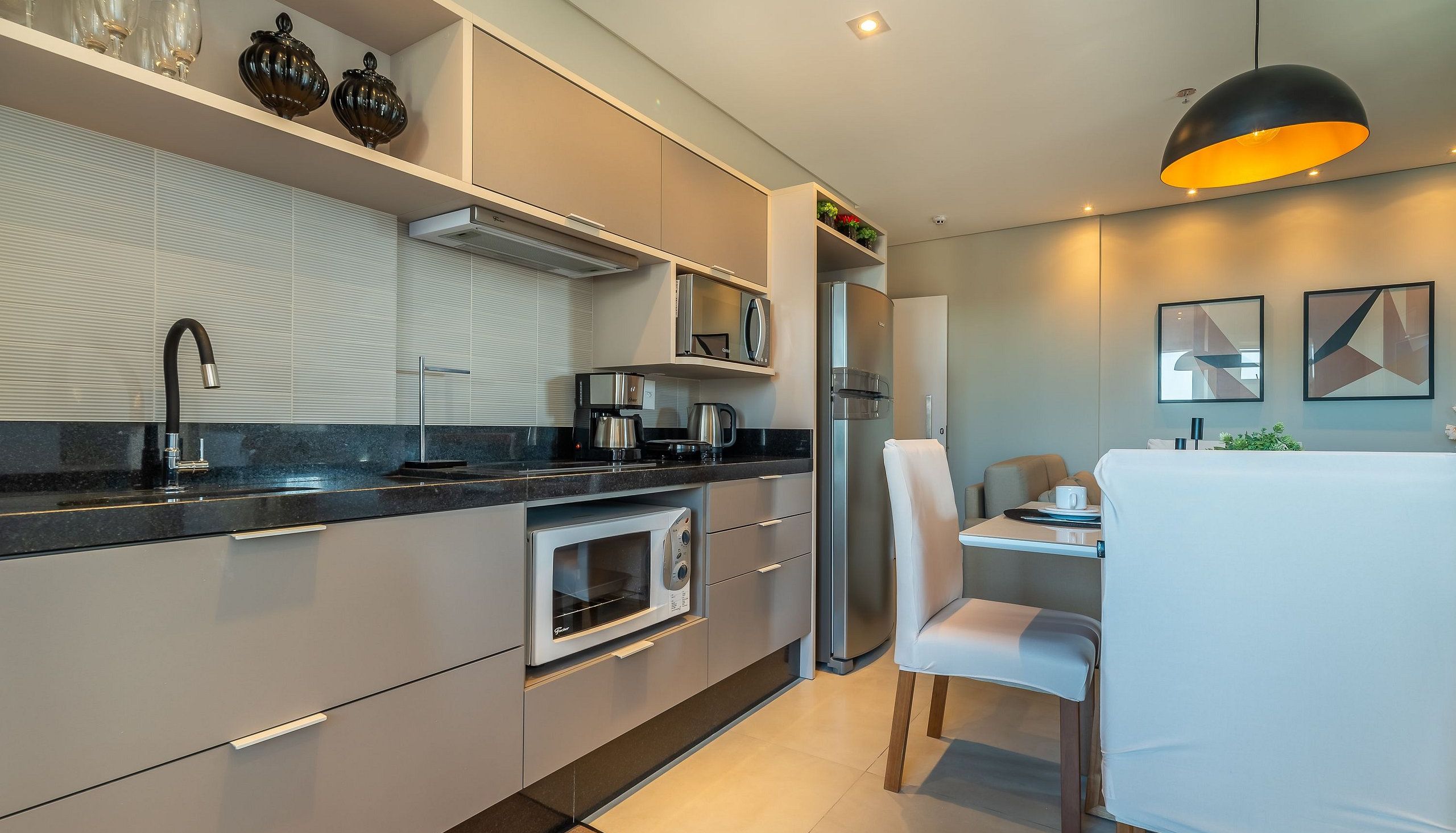A modern kitchen with a built-in oven, microwave, and coffee maker.