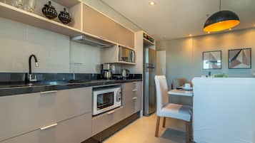 A modern kitchen with a built-in oven, microwave, and coffee maker.