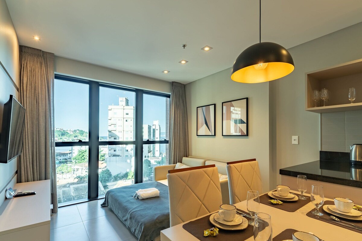 Une chambre d’hôtel moderne équipée d’un lit, d’un coin repas et d’une cuisine.