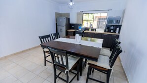 A modern kitchen with a dining area. - Friendly House (Santa Tecla)