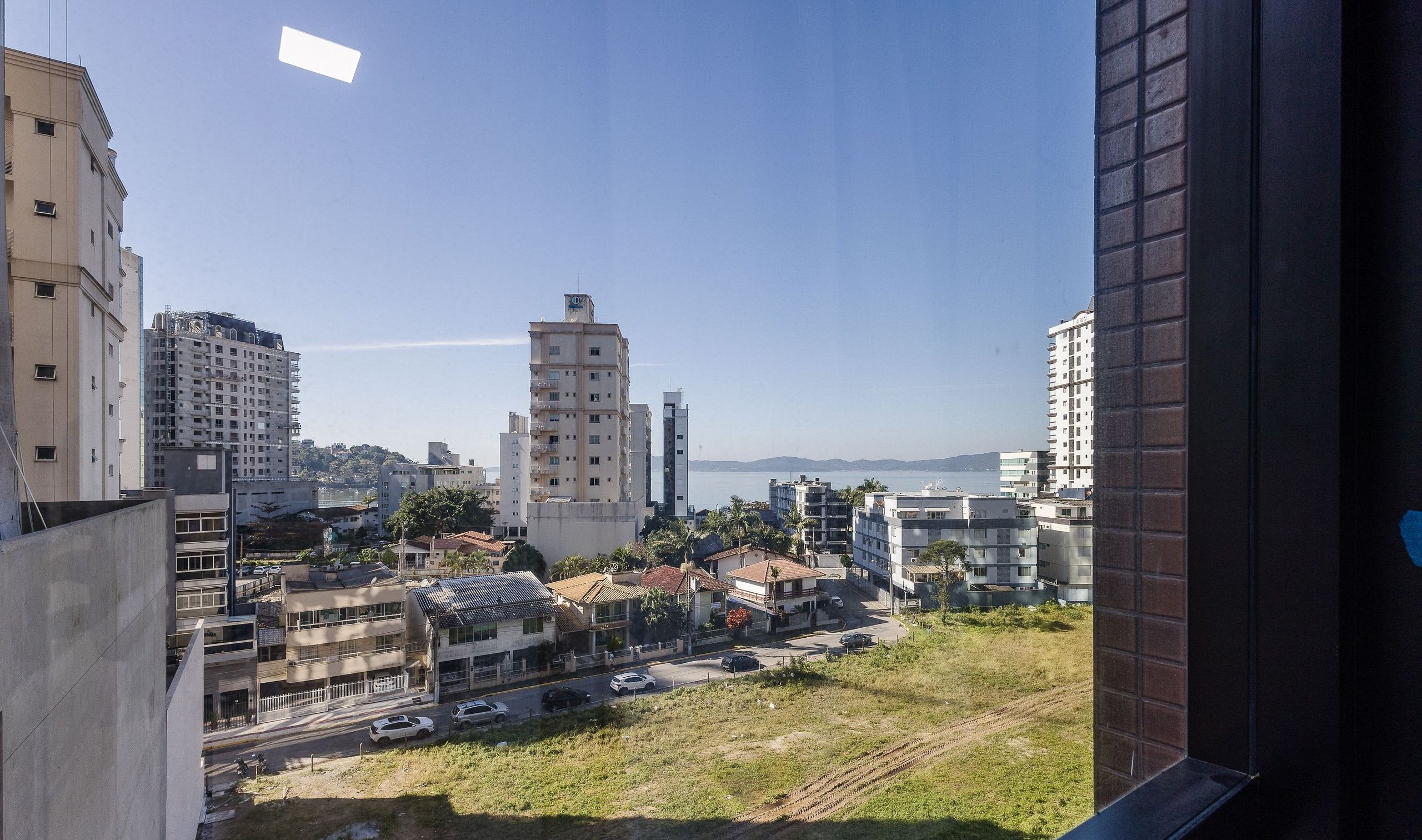 A cityscape with various buildings, including a prominent white tower and several residential structures.