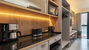 Una cocina moderna con protector salpicadero de madera, horno empotrado, cafetera y vistas a la ciudad a través de un ventanal grande.