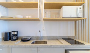 Una cocina moderna con lavavajillas integrado, cafetera, balanza y una tableta sobre la encimera.