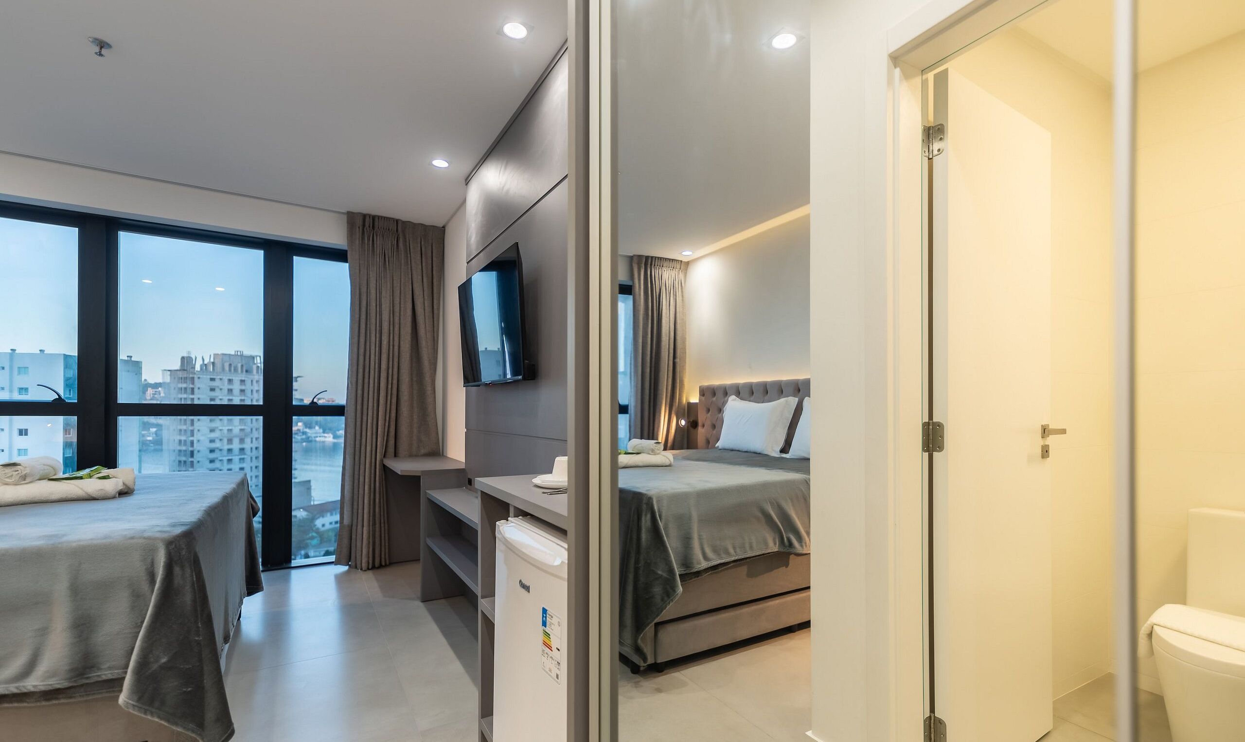 Une chambre d’hôtel avec un lit, un bureau, une télévision et une salle de bain.