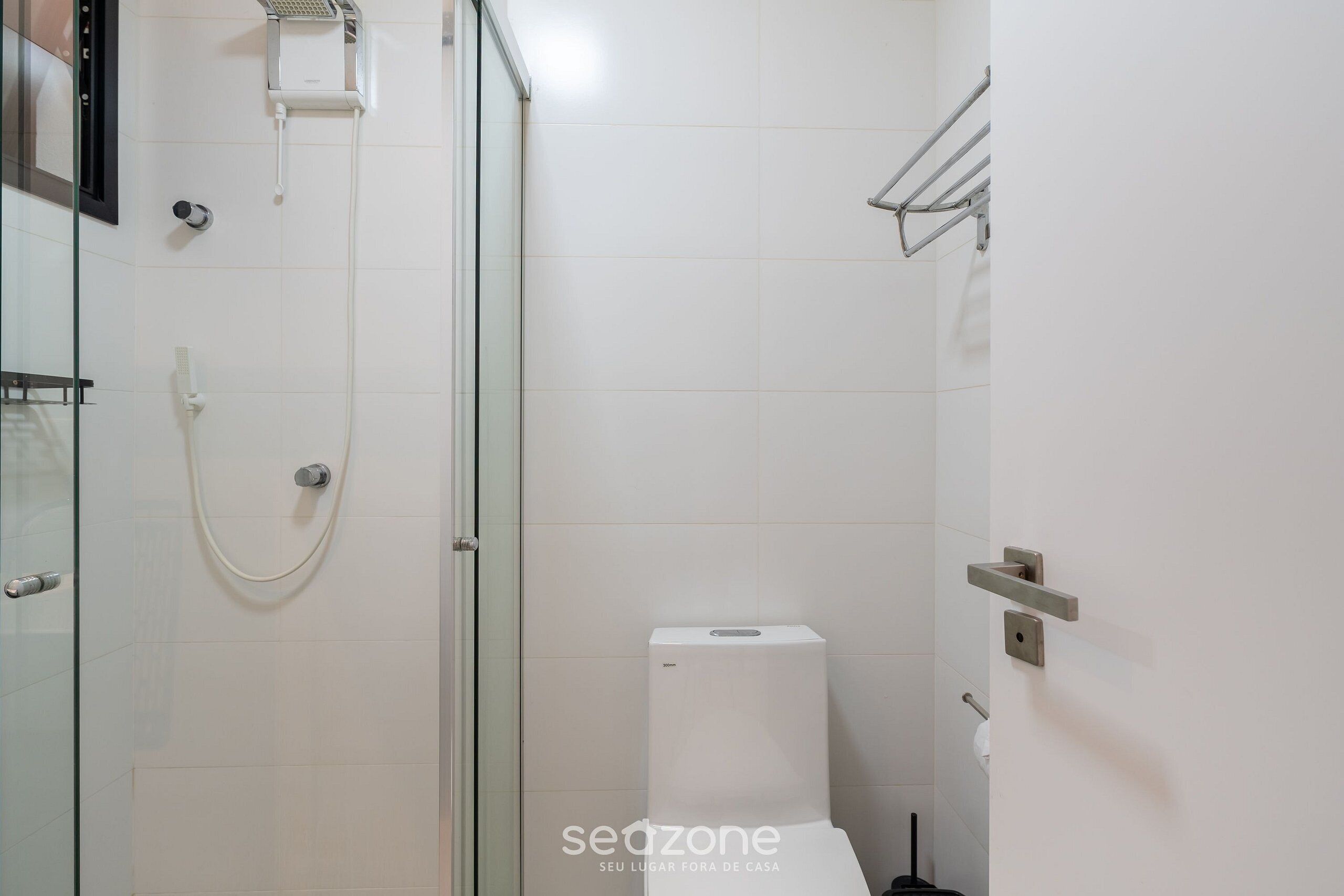 Ein Badezimmer mit Duschkabine, Toilette und Handtuchhalter.