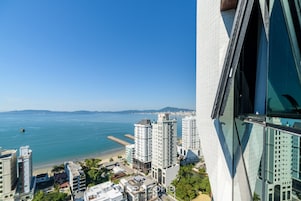 Un edificio de gran altura con vista al océano y a la playa.
