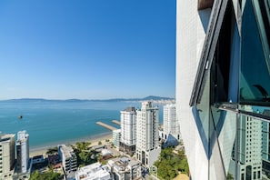 Un immeuble de grande hauteur offrant une vue sur l’océan et la plage.