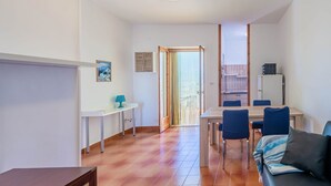 Un espacio habitable compacto con comedor, un sofá, una mesita y una lámpara de techo.