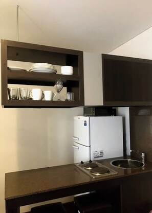 A compact kitchen with a built-in microwave, a white refrigerator, and a stainless steel sink. - Spacious and light apartment- Pto Madero and Centro

 (Buenos Aires)
