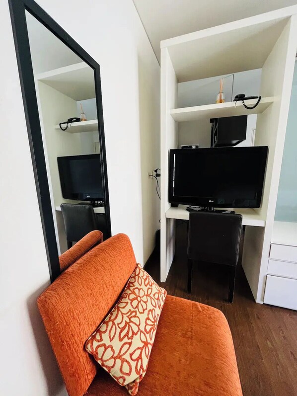 A compact room with a sofa, a television, and a mirror. - Spacious and light apartment- Pto Madero and Centro

 (Buenos Aires)