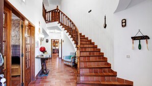 A staircase with wooden railings and a tiled floor leading to a second-floor landing. - Country House 'Quinta Da Violeta' with Sea View, Wi-Fi and Air Conditioning (Loulé)