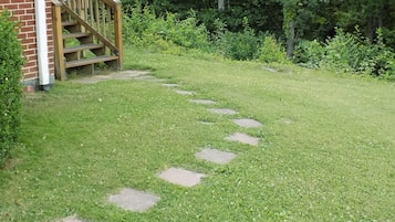 A garden with a stone pathway leading to a wooden staircase.