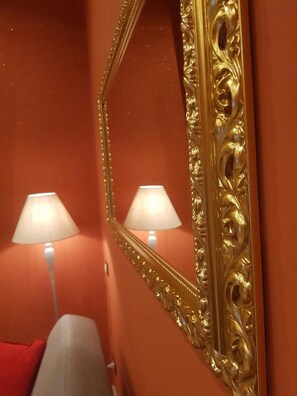 Reflect on the room's elegant decor, featuring a large mirror and warm-toned walls.
