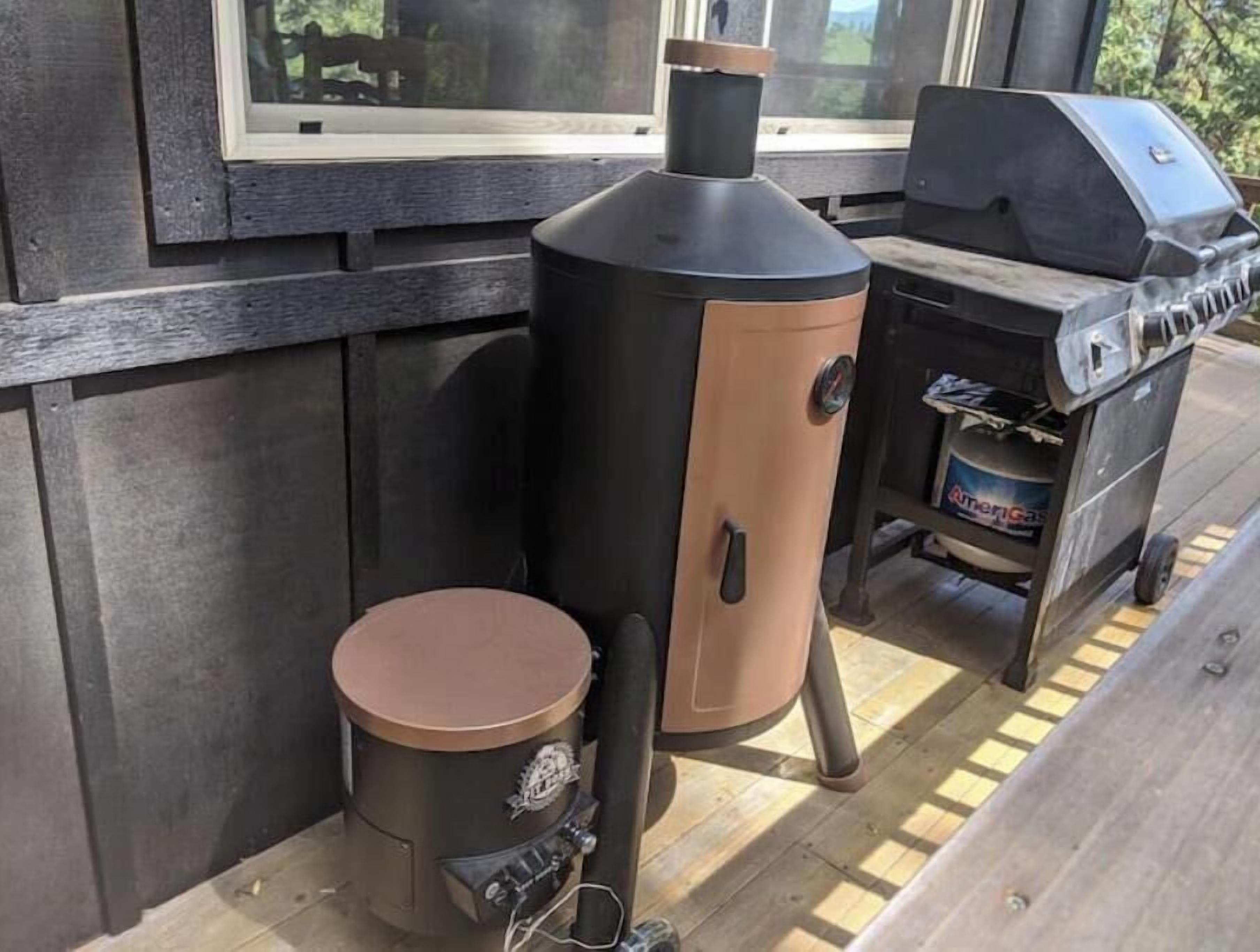 Una instalación de parrilla y ahumador portátil sobre una terraza de madera.
