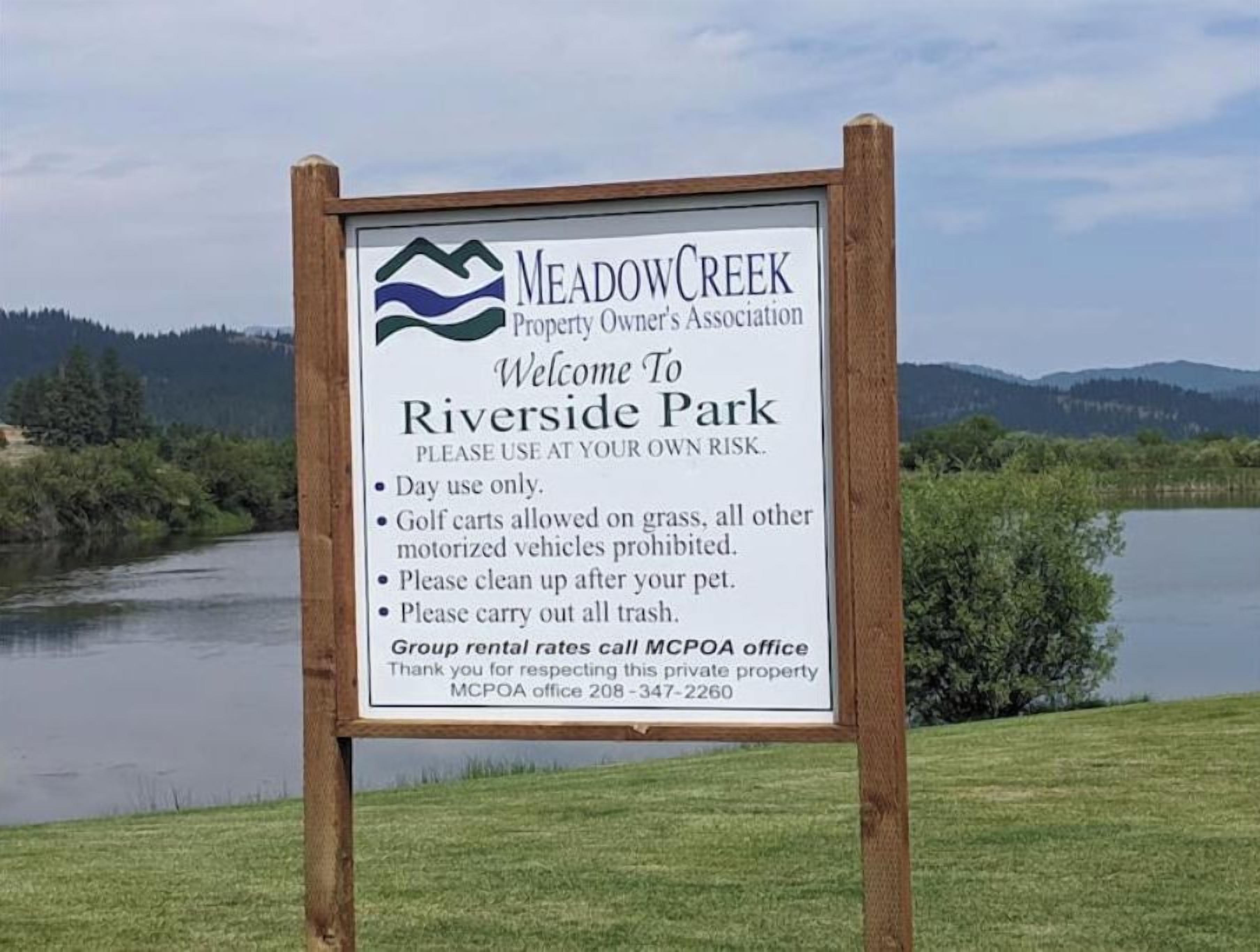 Schild für Riverside Park, erstellt von der Meadow Creek Property Owners' Association, mit Regeln und Kontaktinformationen.