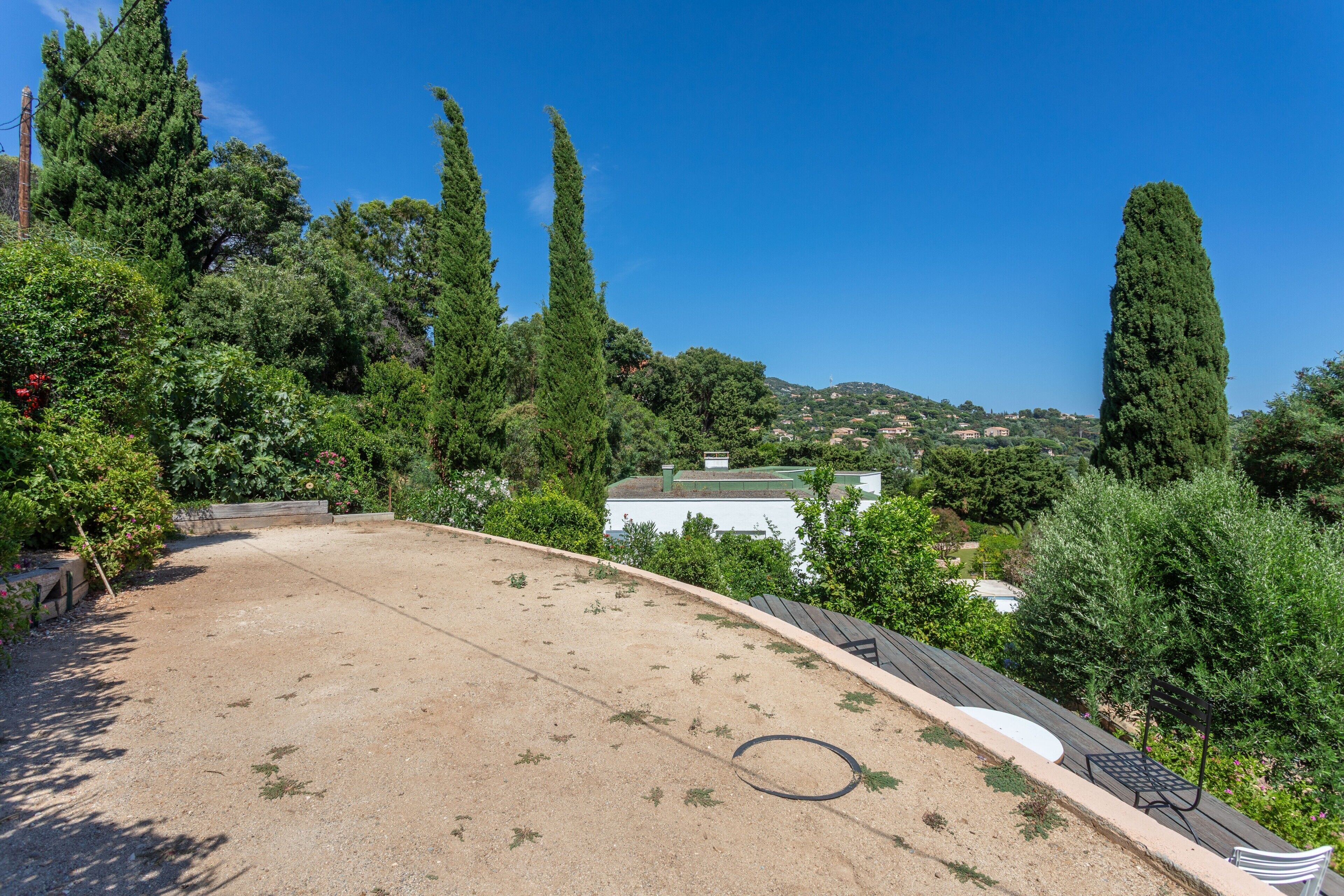 Un jardin sur le toit offrant une vue sur un bâtiment blanc et sur des collines au loin.