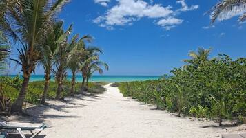 Praia particular, areia branca, espreguiçadeiras, toalhas de praia