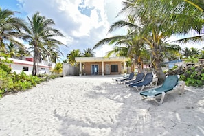 Praia particular, areia branca, espreguiçadeiras, toalhas de praia