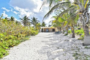 Praia particular, areia branca, espreguiçadeiras, toalhas de praia