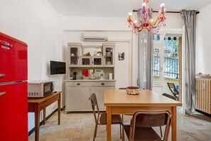 A compact kitchen with a microwave, a television, and a cabinet with glass doors.