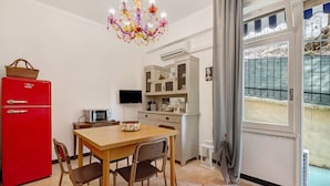 A compact kitchen with a red refrigerator, a microwave, and a dining table with chairs. - Apartment 'Lulu' with Private Terrace, Wi-Fi, Convenient for Cinque Terre and Portofino (Lavagna)