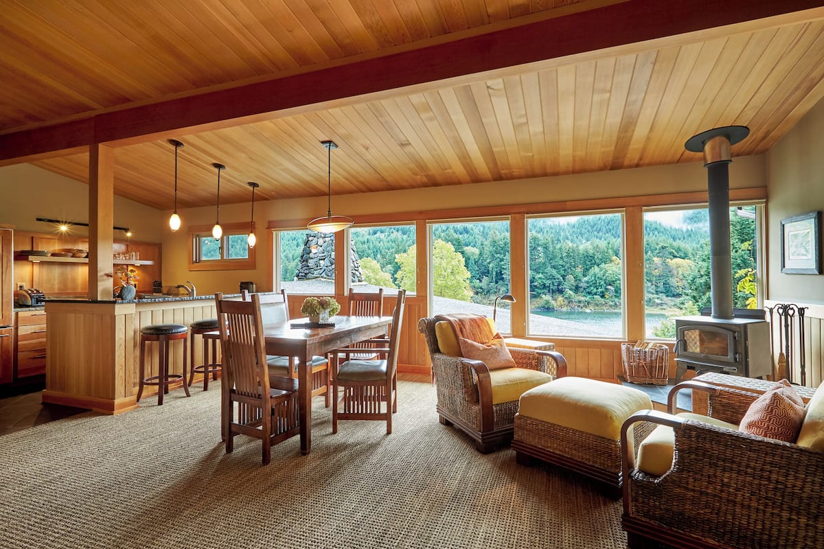 Un amplio espacio de estar con una gran mesa de comedor de madera, asientos cómodos y vistas al exterior.