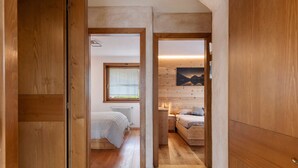 Un interior de madera con una cama, una mesita de noche y un cuadro en la pared.