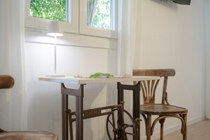 Une table avec un plateau blanc et une chaise ancienne dotée d’une structure en métal, sur laquelle on peut lire le mot « SIGMA ».