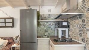 Cocina compacta con refrigerador, microondas y lavabo.