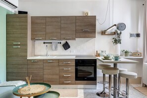 Une cuisine moderne avec des meubles en bois, un lave-vaisselle, un évier et un coin bar avec des tabourets.