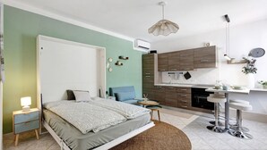 Ein Schlafzimmer mit einem Bett, einem Nachttisch und einem kleinen runden Tisch mit Stühlen.