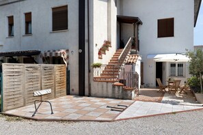 Un patio con escaleras, asientos al aire libre y un banco de madera.