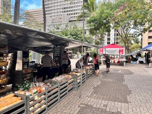 A bustling outdoor market with vendors selling bread and other goods under shaded canopies. - 3BR Townhome condo in Downtown/Free Pkg/Washer/Dryer/Huge Patio/Pool (Honolulu)