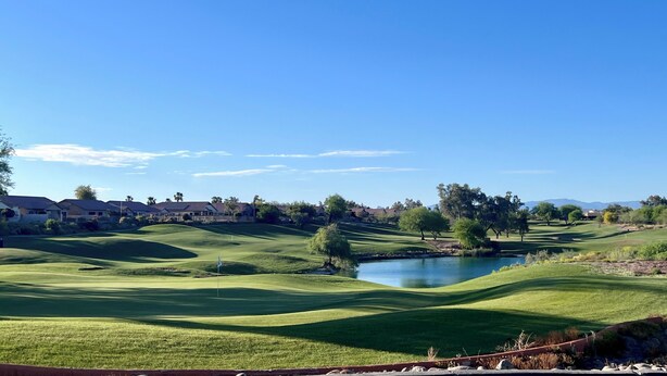 A golf course with a pond, houses in the background, and a clear blue sky. - Desert Oasis / Heated Pool / Spring Training / Barrett-Jackson / WM Phoenix Open (Surprise)