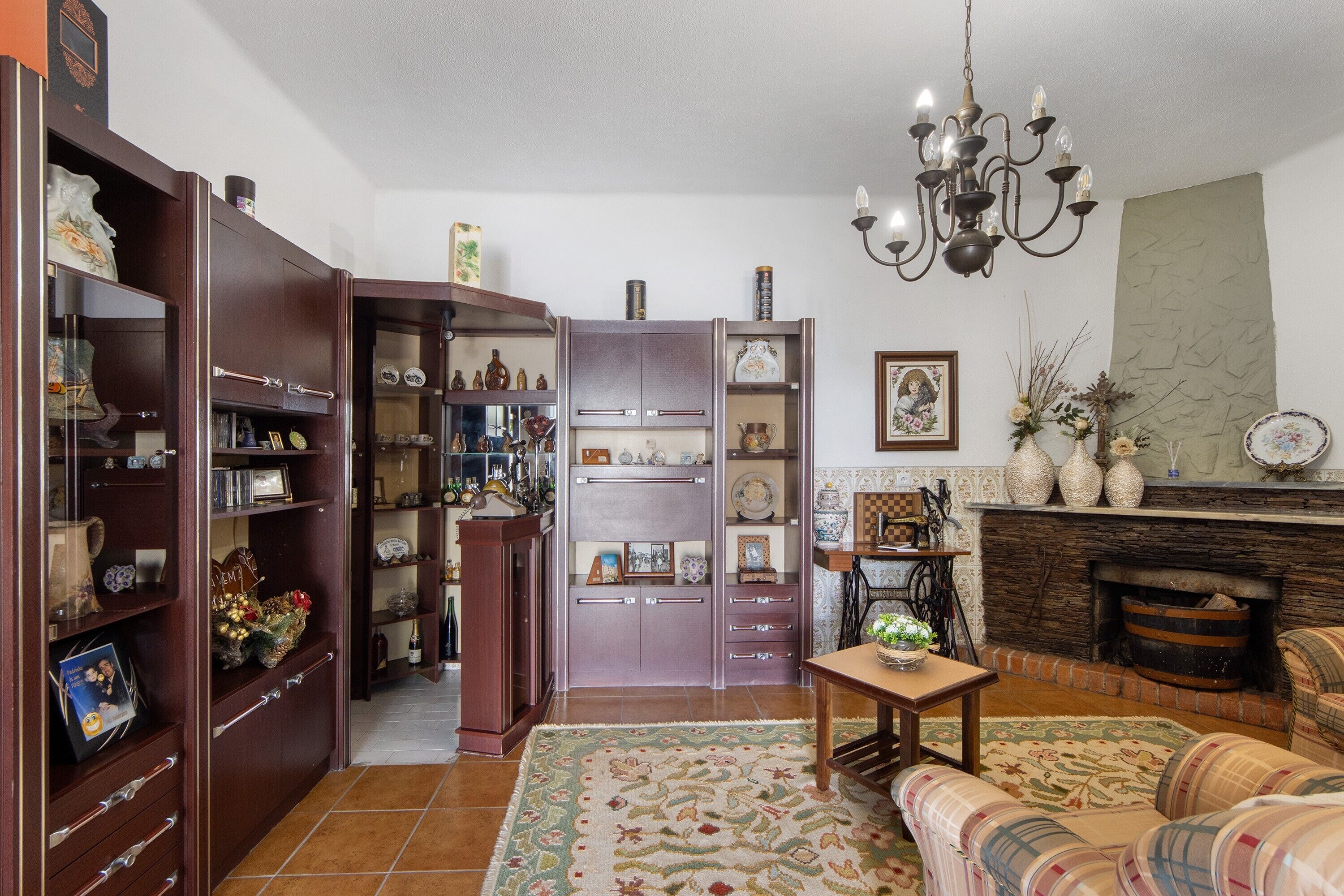 A living room with a fireplace, a sofa, a coffee table, and a bookshelf.