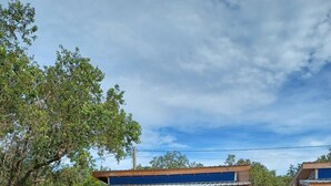 Eine Holzterrasse mit Pool, ein kleines Gebäude mit blauer Fassade und einem Rettungsring.