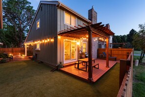A two-story house with a deck, outdoor seating, and string lights. - Charming Arvada Home, Community Pool Jun-Aug (Arvada)