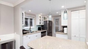 A modern kitchen with white cabinetry, a granite countertop, and stainless steel appliances. - Charming Arvada Home, Community Pool Jun-Aug (Arvada)