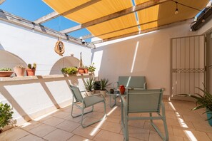 An outdoor patio with a table and chairs, potted plants, and a wooden ceiling. - Holiday Home 'Civico4 Luxuryholidays' with Private Terrace, Wi-Fi and Air Conditioning (Casarano)
