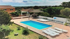 A rectangular swimming pool with a tiled deck, surrounded by a low wall and a few trees. - Chalet 'Villa Con Piscina Privada' with Private Pool, Private Terrace and Wi-Fi (Mas Vilet dels Pins)