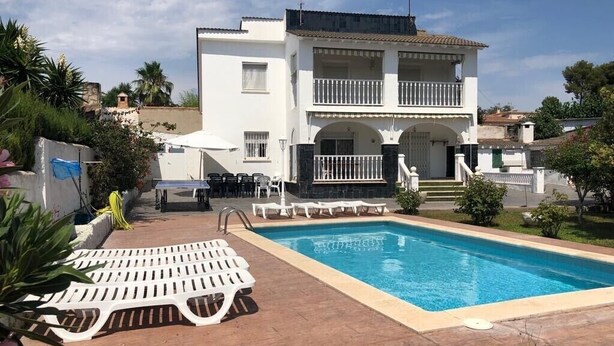 A two-story building with a swimming pool, outdoor seating, and a well-maintained garden. - Chalet 'Villa Con Piscina Privada' with Private Pool, Private Terrace and Wi-Fi (Mas Vilet dels Pins)