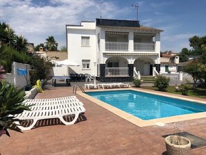 Ein zweistöckiges Gebäude mit Pool, Außenbereich und einem gepflegten Garten.