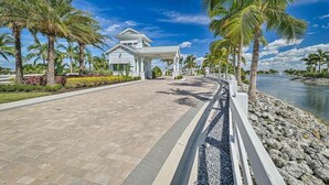 Un resort con un camino pavimentado, palmeras y un edificio de fachada blanca.