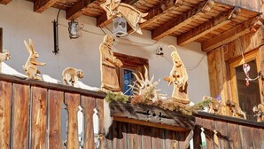 Ein hölzerner Balkon mit geschnitzten Tierfiguren und rustikalem Design.